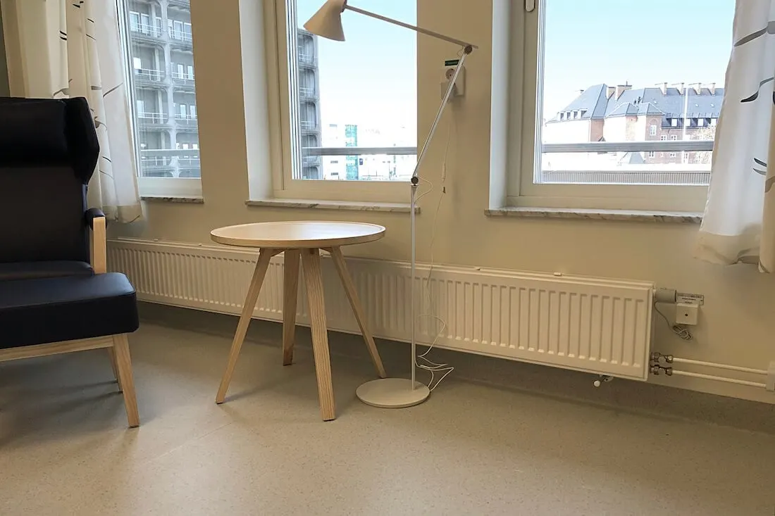 Lyngson-hygieniaradiaattori ikkunan alla valoisassa hoitotilassa